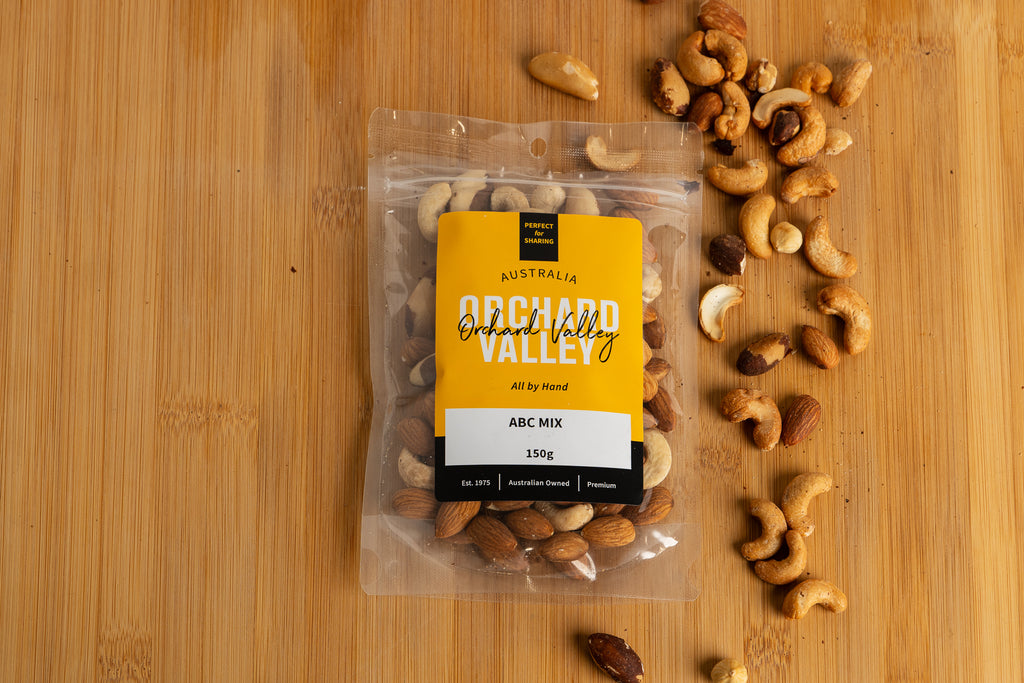Packaged ABC mix of nuts on a wooden surface with Orchid Valley branding.