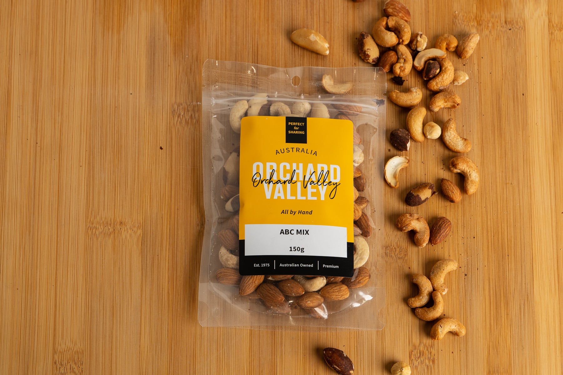 Packaged ABC mix of nuts on a wooden surface with Orchid Valley branding.